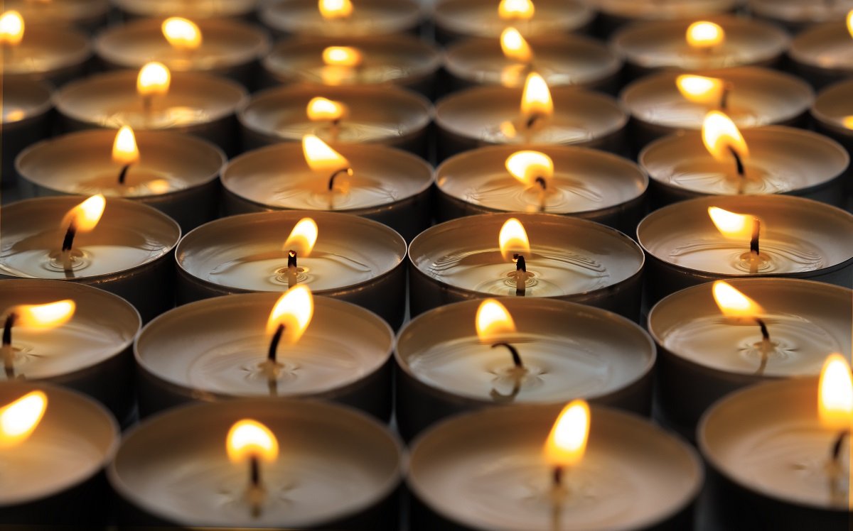 Many small roundness burning candles, close up.